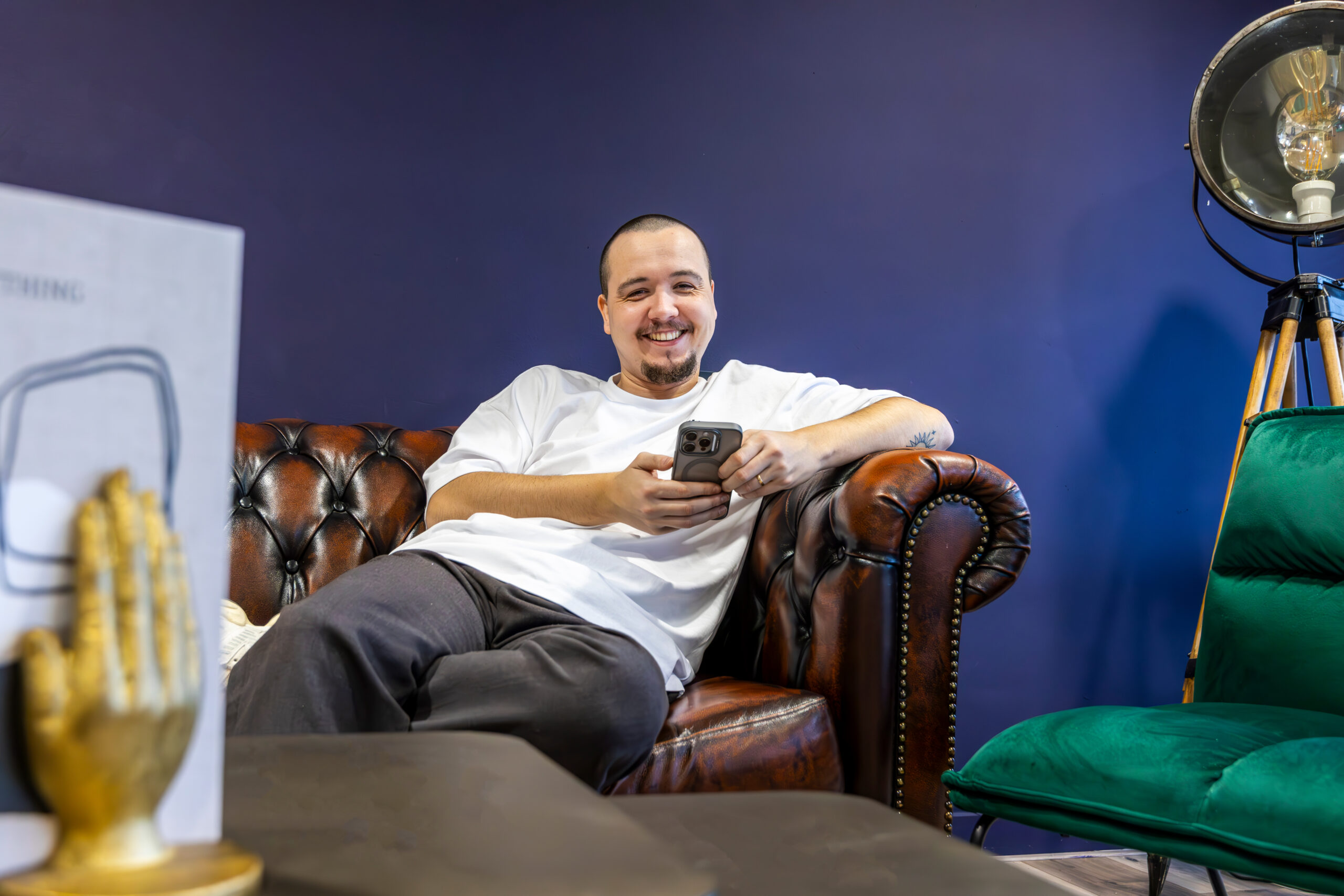 Steffen Lautenbach op de bank met een mobiel in zijn hand